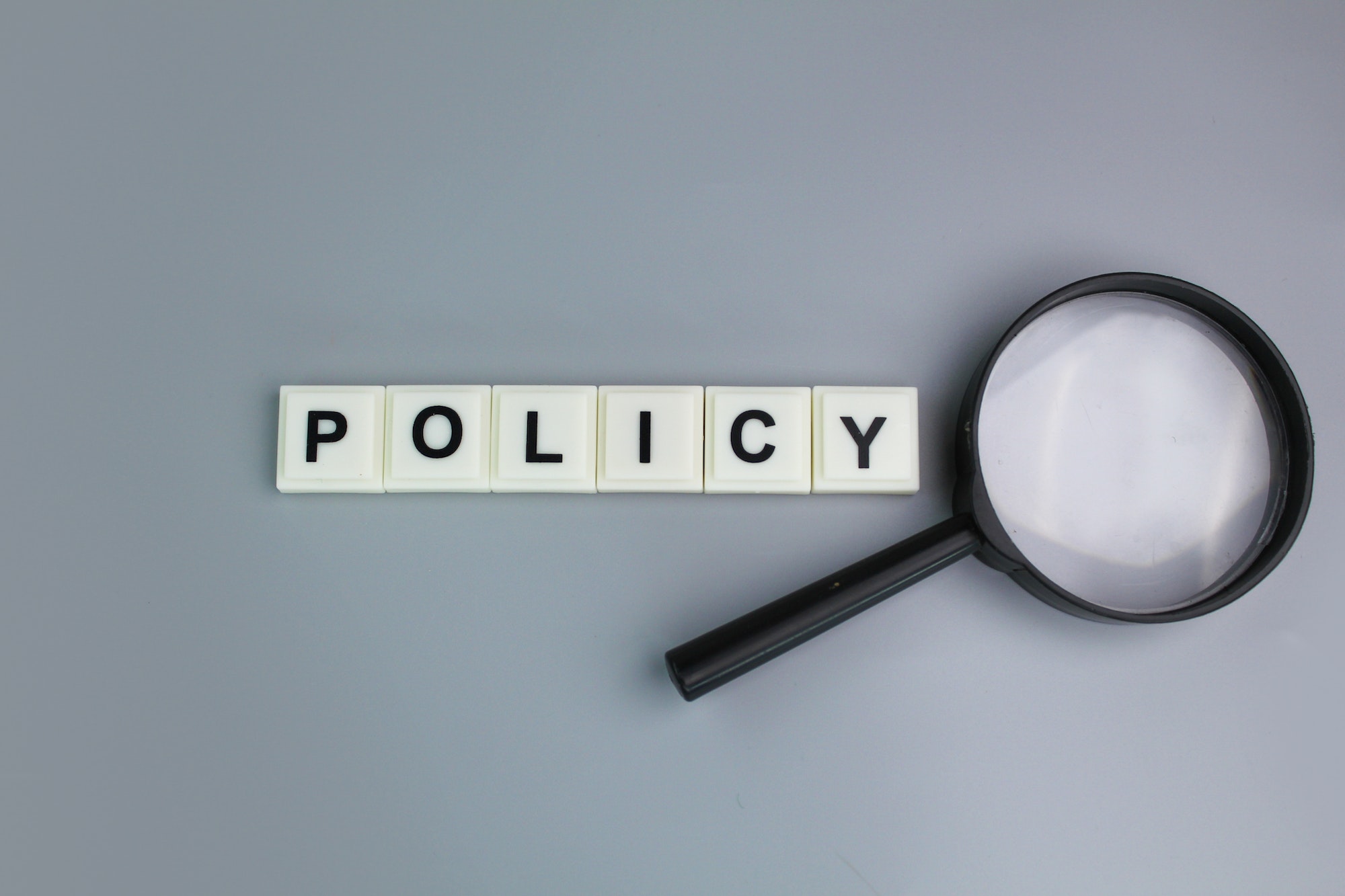 magnifying glass with alphabet letters of the word policy